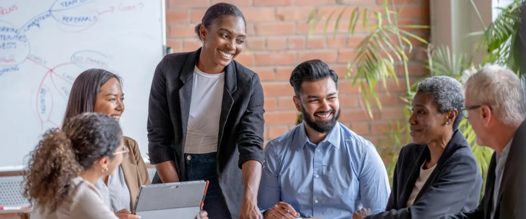 Group of employees smiling together, representing HR teams navigating 2025 employee gift tax rules and recognition compliance.